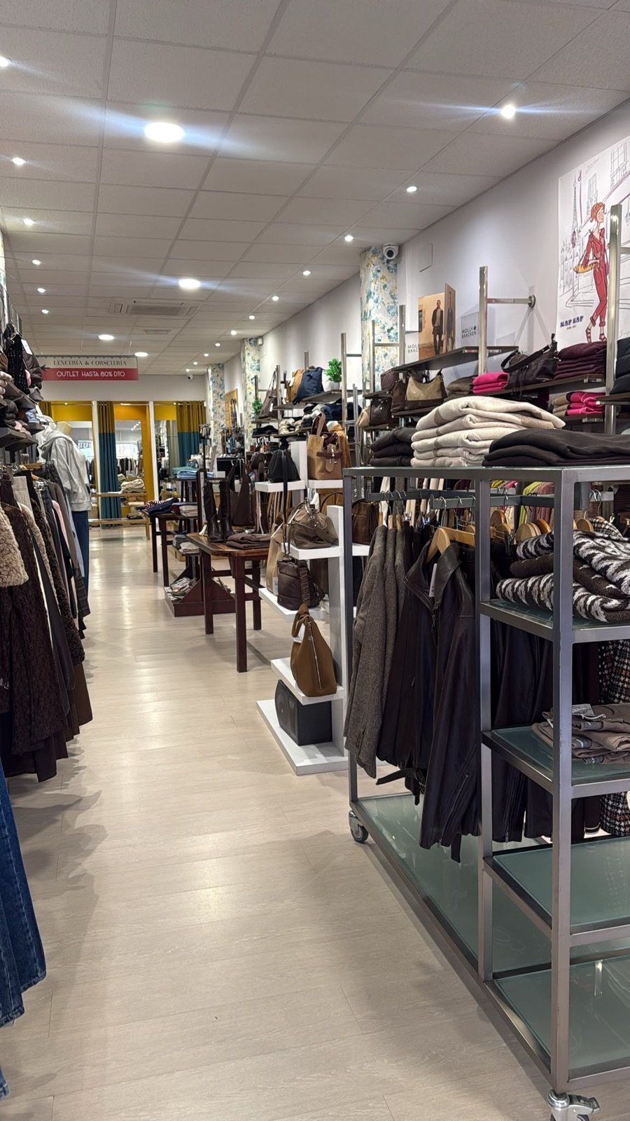 La tienda Duna Boutique en Tarancón a lo largo del pasillo, con burros y estanterías de ropa